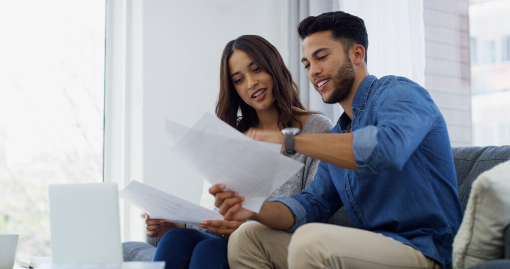 Couple sitting on a couch discusses finances