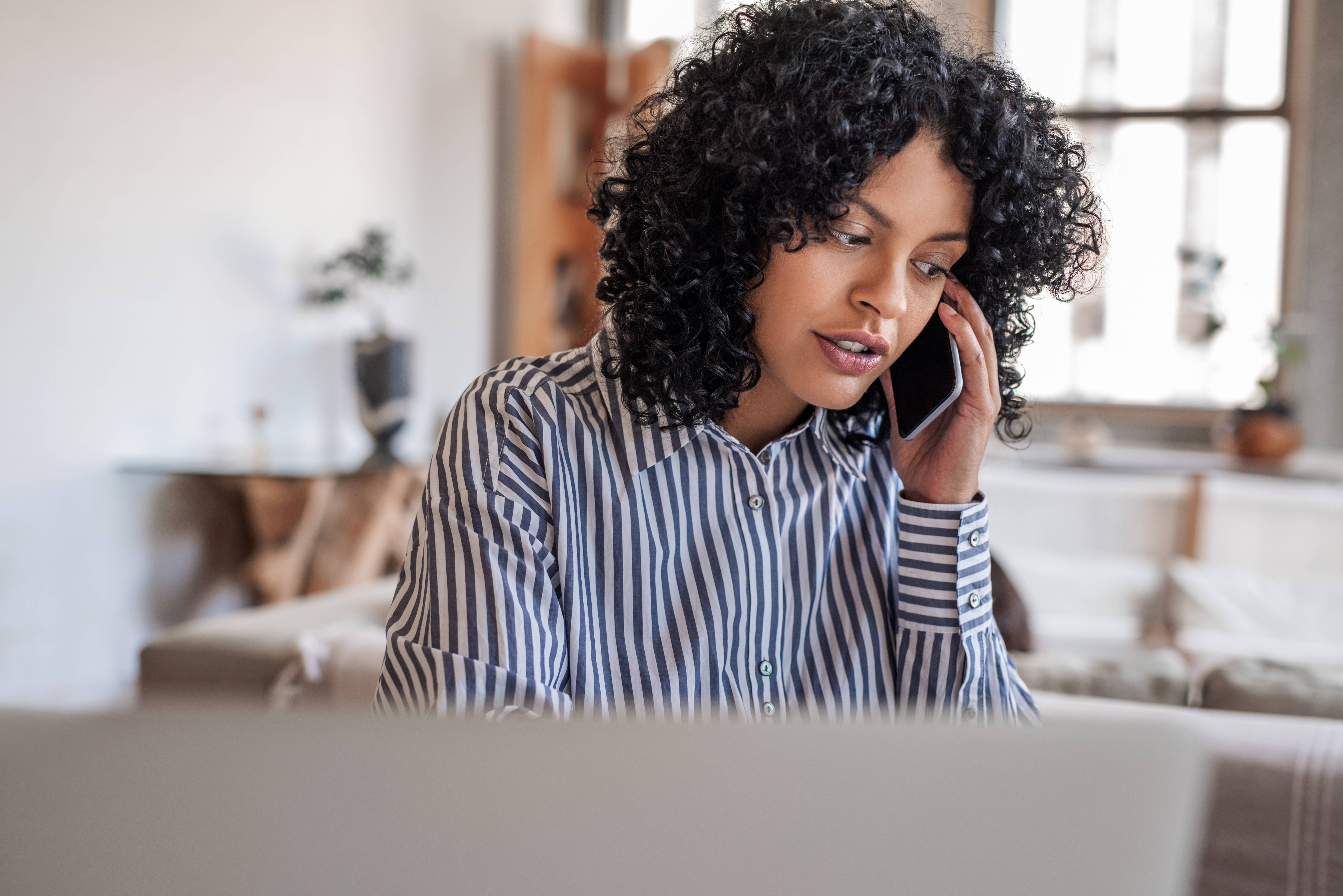 Young woman with curly, dark hair talking on cell phone