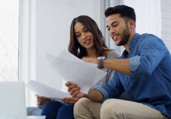 Couple sitting on a couch discusses finances