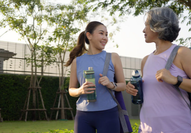 Young woman walking next to aging woman having conversation